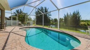 Una piscina interior con vistas despejadas del paisaje circundante, un porche cubierto y una zona de estar junto a la piscina.