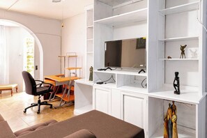 A room with a desk, chair, shelves, and a television. - The hillls - Beverly Hills overlooking Kingston (Kingston)