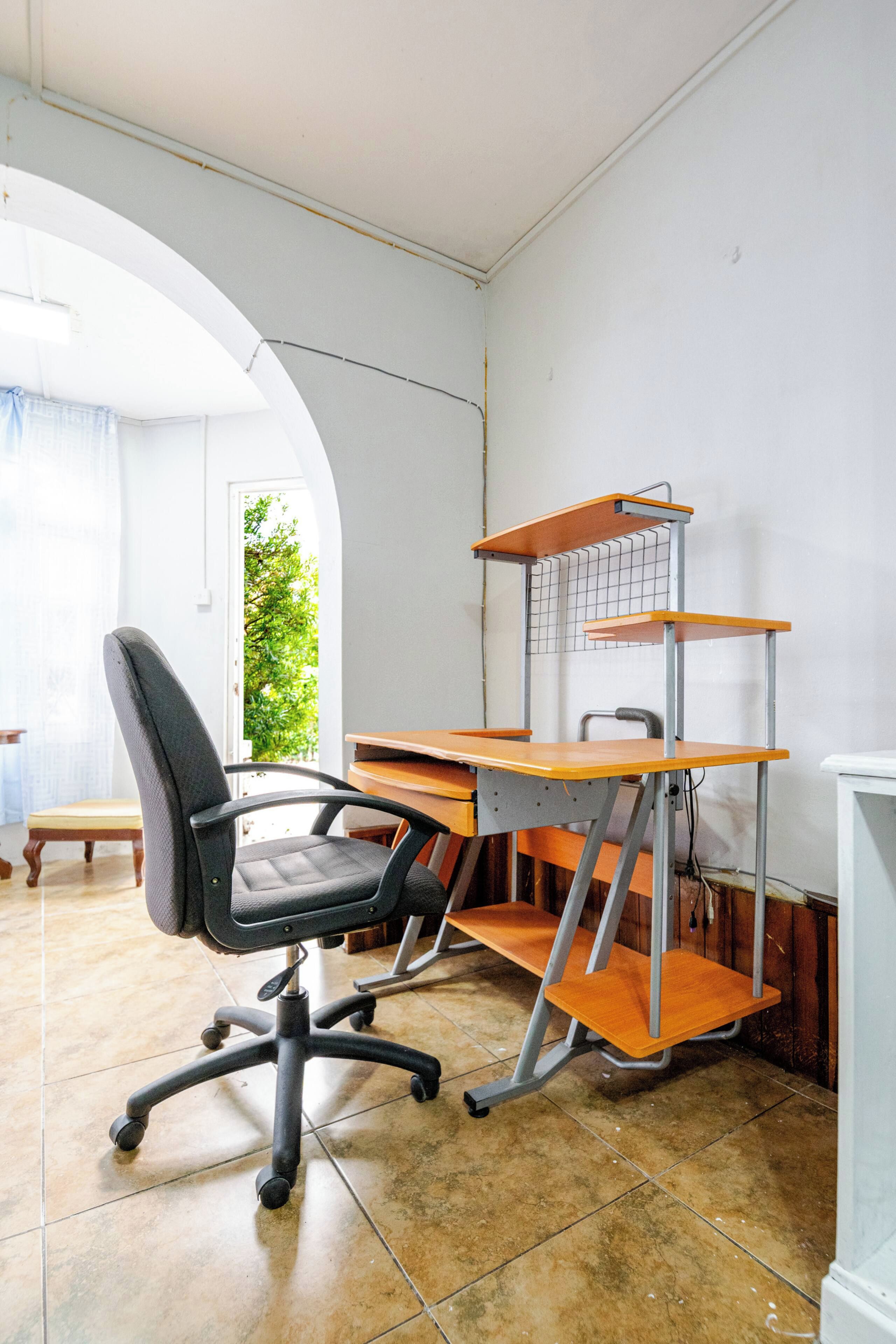 Una habitación con escritorio, silla y estantería.