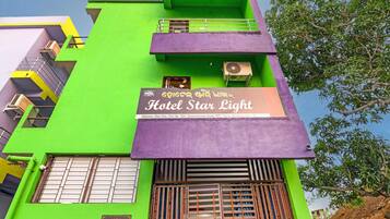 A multi-story building with a sign for 'Hotel Star Light' and an air conditioning unit on the exterior.
