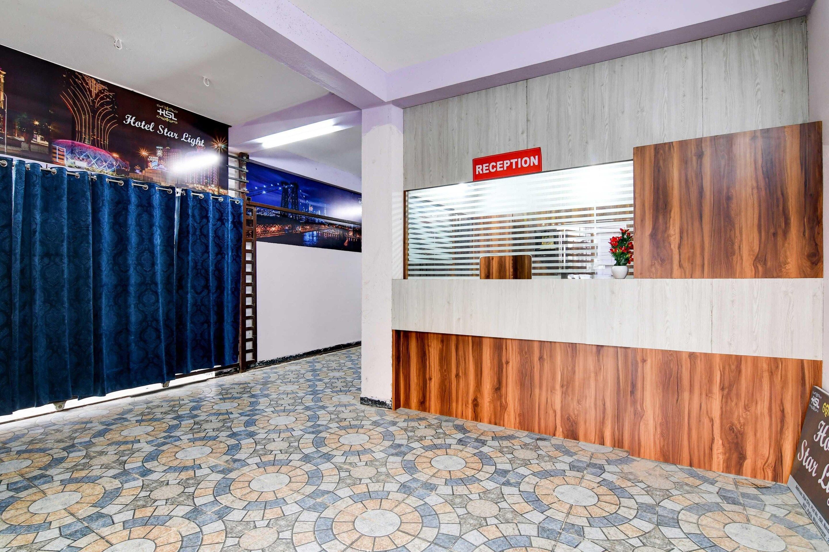 A hotel reception area with a reception desk, a reception sign, and a patterned floor.