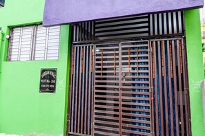 Un edificio verde con una reja metálica y un cartel que indica 'UGRESAN NINAS PLOT NO- 268 STAR CITY, PATIA'.
