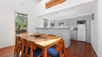 A modern kitchen with white cabinets, a built-in oven, and a refrigerator.