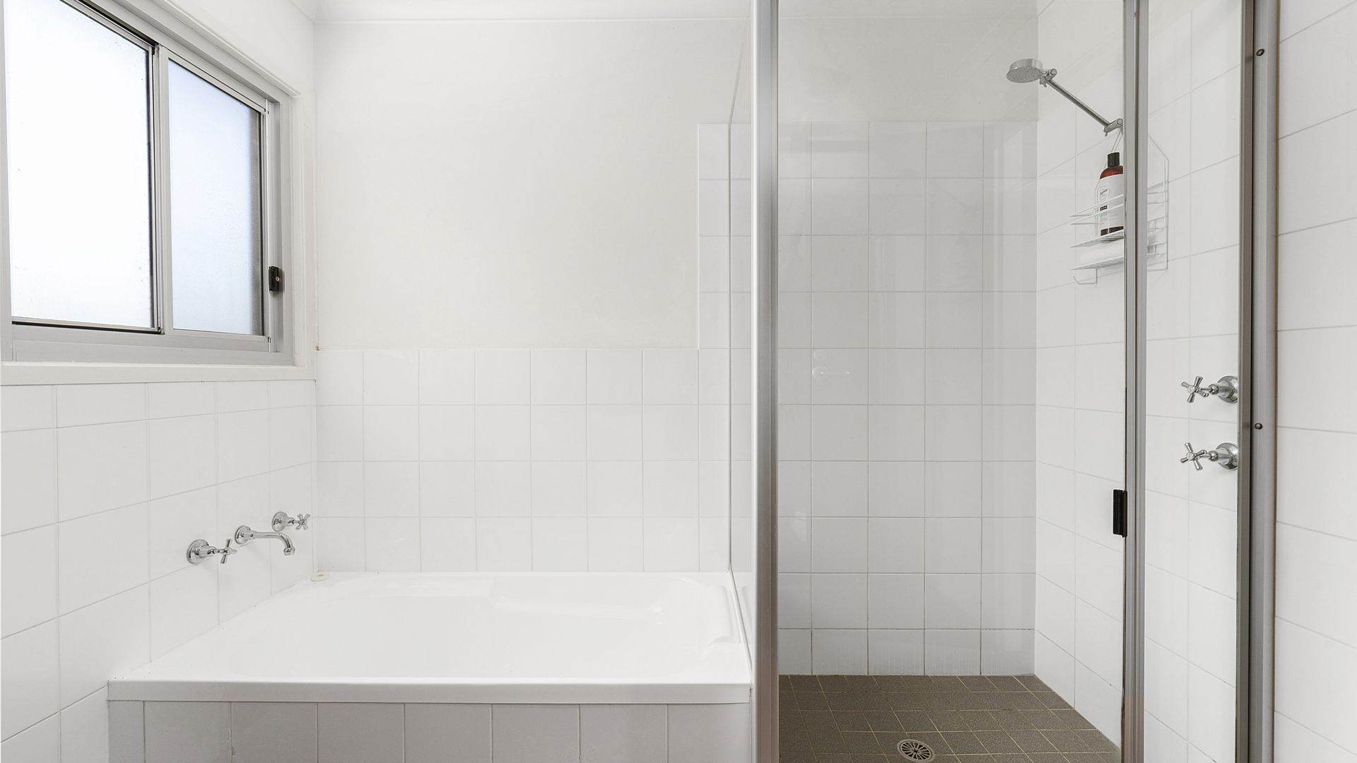 A bathroom with a bathtub, a shower, and a window.