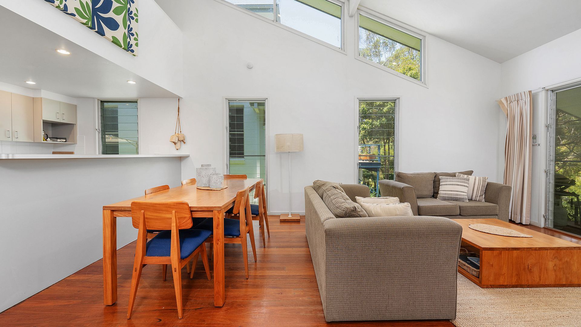 A modern living space with a dining area, a sofa, and a coffee table.