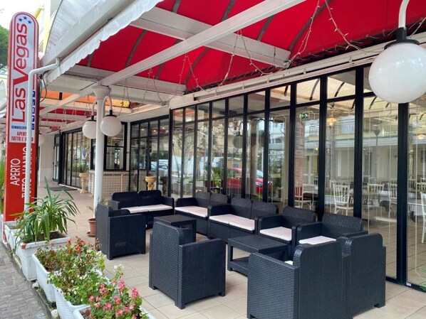An outdoor seating area with wicker furniture and a red awning.