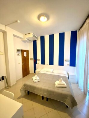 A hotel room with a bed, a bedside table, a bathroom, and a window with curtains. - Hotel LAS vegas  (Riccione)