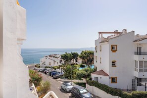 A coastal residential area with white buildings, a clear sky, and a view of the sea. - Coastal 2‑Bed Retreat Filled with Spanish Charm - Pass the Keys (Benalmadena)