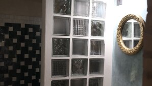 A bathroom with a tiled wall, a sink with a gold faucet, and a mirror with a decorative frame. - Cedar, Lime & Light – A Boutique Auberge at Chefchaouen's Historic Gate (Chefchaouen)