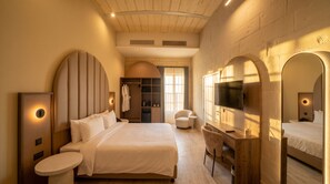 Una habitación de hotel moderna con una cama grande, un escritorio, un televisor y un vestidor.