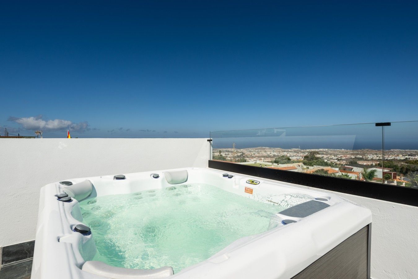 A hot tub on a rooftop with a cityscape view.