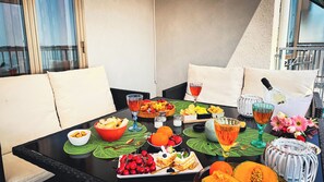 A dining table set with various fruits, a bottle of wine, and a decorative centerpiece. - Canal Bellavista by Ca-sa Check (Chioggia)