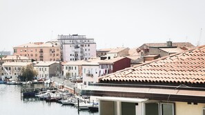 A marina with boats docked, surrounded by buildings with terracotta roofs and a mix of architectural styles. - Canal Bellavista by Ca-sa Check (Chioggia)