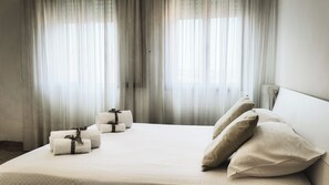 A hotel room with a large bed, white linens, and a view through sheer curtains. - Canal Bellavista by Ca-sa Check (Chioggia)