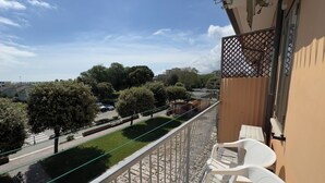 A balcony with a view of a street, trees, and a building in the background. - Farmont Residence Alice by Ca-sa Check (Chioggia)