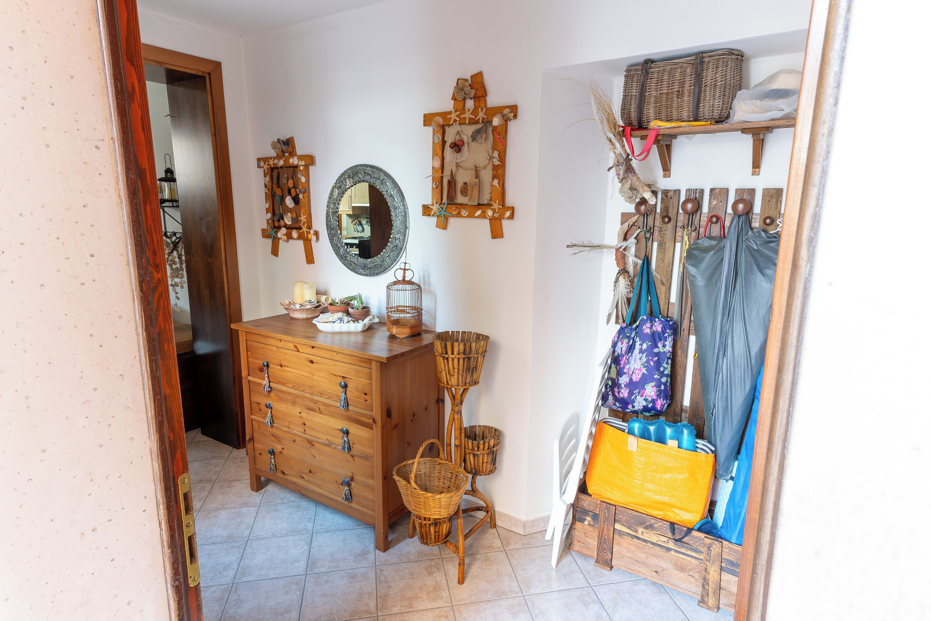 Une pièce comprenant une commode en bois, un miroir et une petite table ornée d’objets décoratifs.