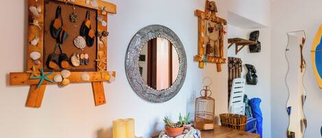 A room with a wooden dresser, a mirror, and various decorative items including seashells and a wooden cross.