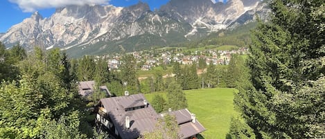 A mountain landscape with a village and houses surrounded by greenery.