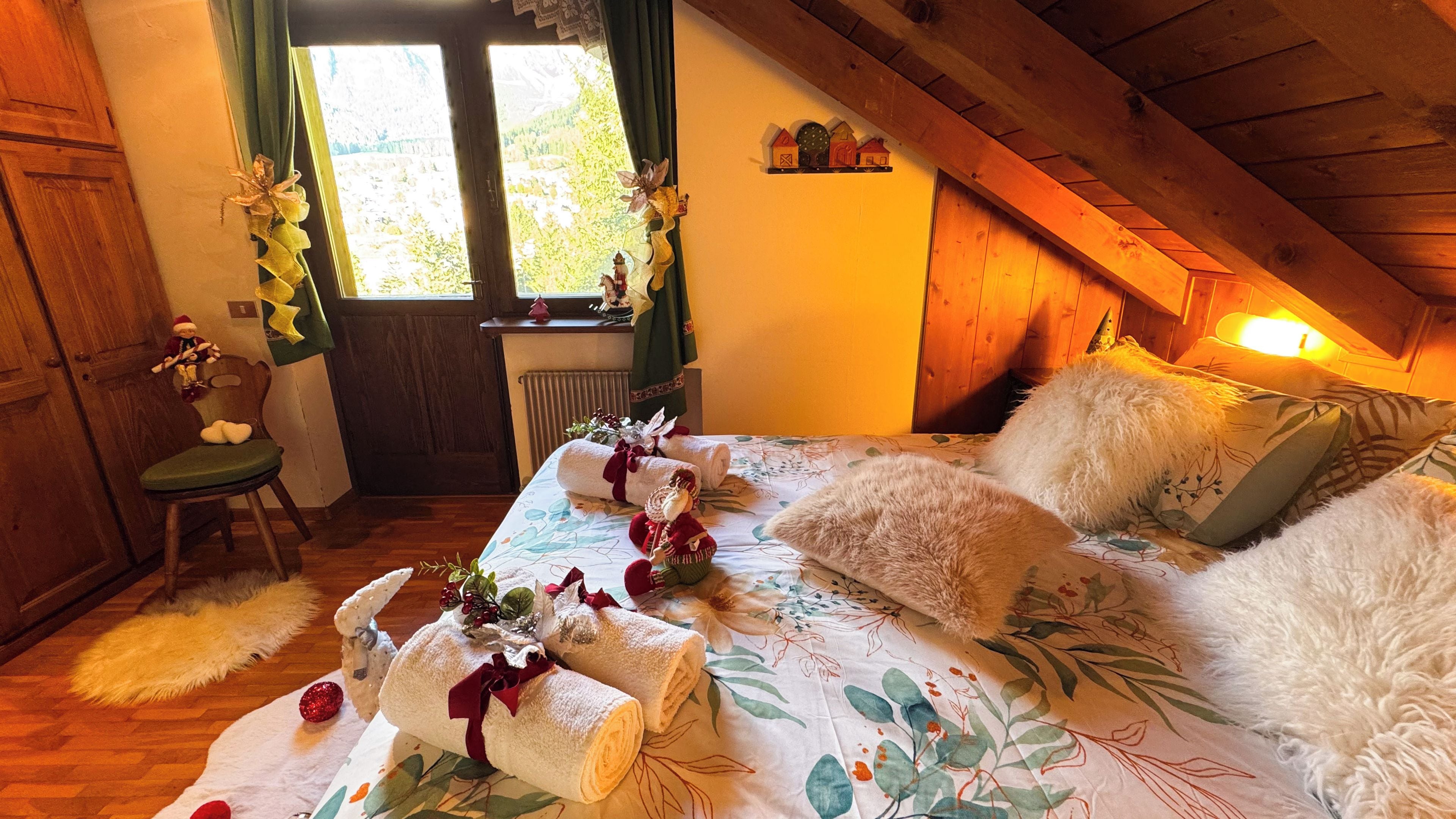 Une pièce confortable avec un lit, une chaise et une fenêtre avec des rideaux.