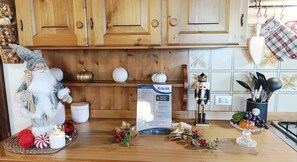 A kitchen with wooden cabinets, a nutcracker, a candle, and holiday decorations. - Chalet Stravedo by Ca-sa Check (San Vito di Cadore)