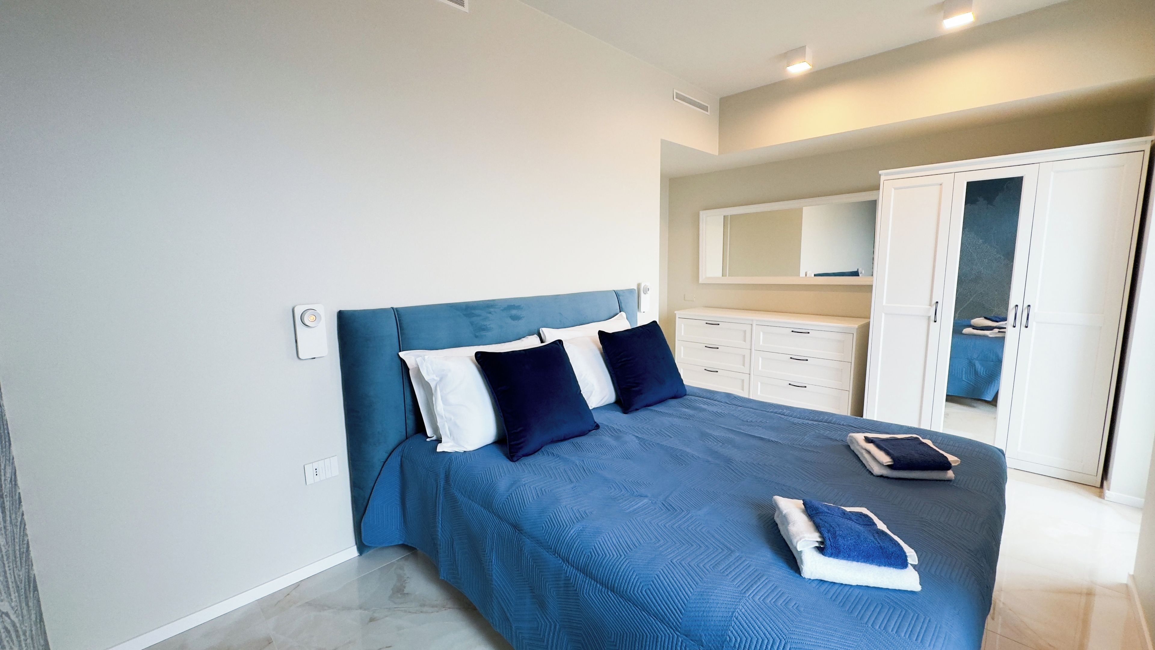 Ein Schlafzimmer mit einem Bett, einem Kleiderschrank und einem Spiegel.