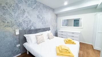 Ein Schlafzimmer mit einem Bett, einem Schminktisch, einem Spiegel und einem Kleiderschrank.