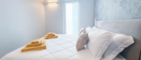 Quarto de hotel com cama, travesseiros e janela.