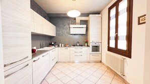 A modern kitchen with light wood cabinets, a gas stove, an oven, and a built-in microwave. - Lady Teresa 2.0 by Ca-sa Check (Chioggia)