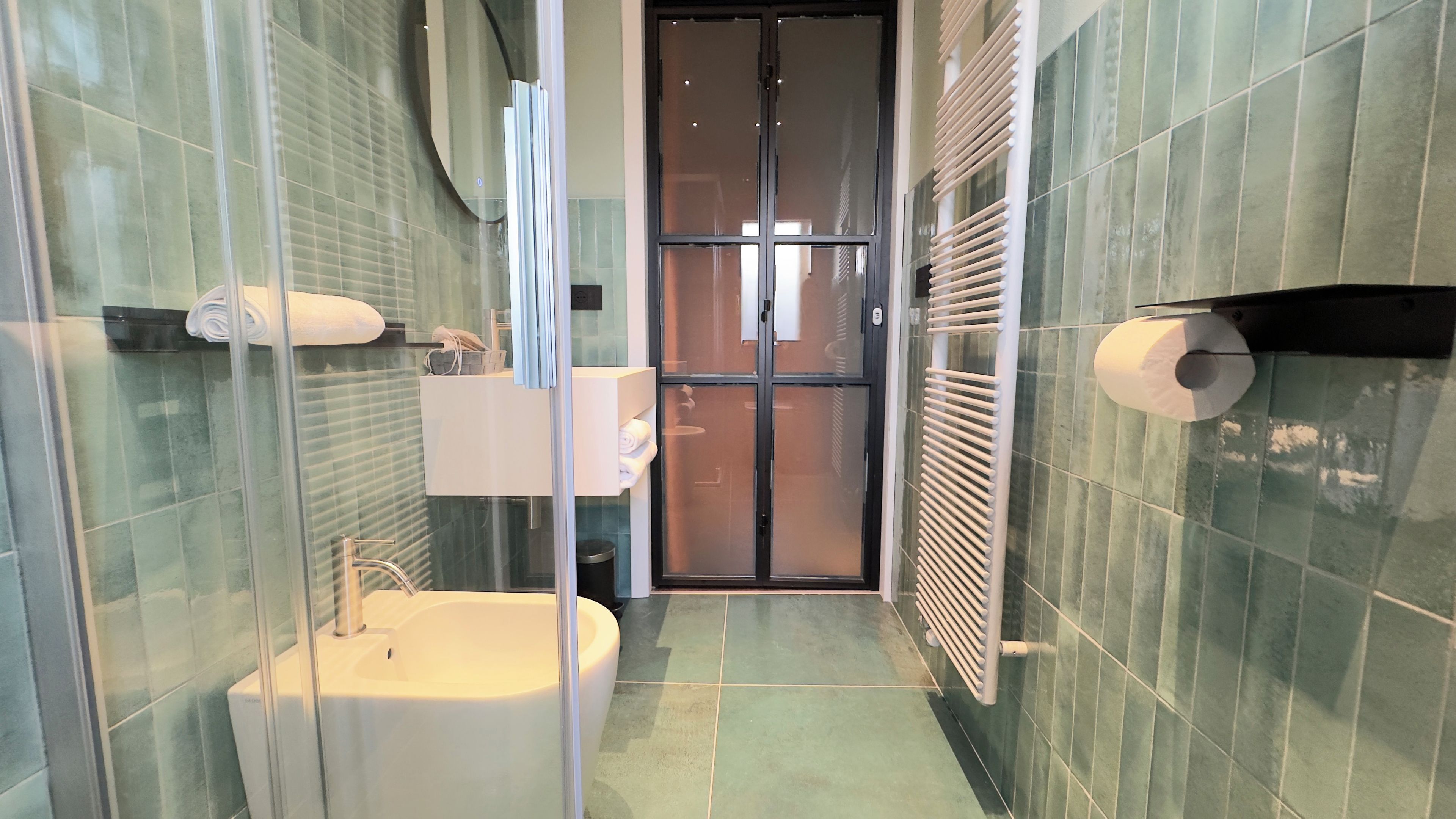 Une salle de bain moderne avec une douche à parois de verre, un lavabo et des toilettes.