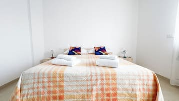 A hotel room with a bed, two bedside tables, and a nightstand.