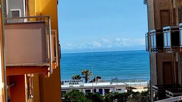 A view of the sea from a balcony with a restaurant named "Ristorante Pizza" in the background.