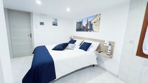 A hotel room with a bed, bedside table, lamp, and a wall-mounted painting. - Blue Eyes by Ca-sa Check (Chioggia)
