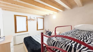 A bedroom with a bunk bed, a radiator, a wooden ceiling, and a window with curtains. - Romantic Flower by Ca-sa Check (Chioggia)