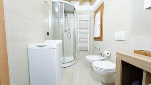 A modern bathroom with a glass shower enclosure, a toilet, and a sink. - Romantic Flower by Ca-sa Check (Chioggia)