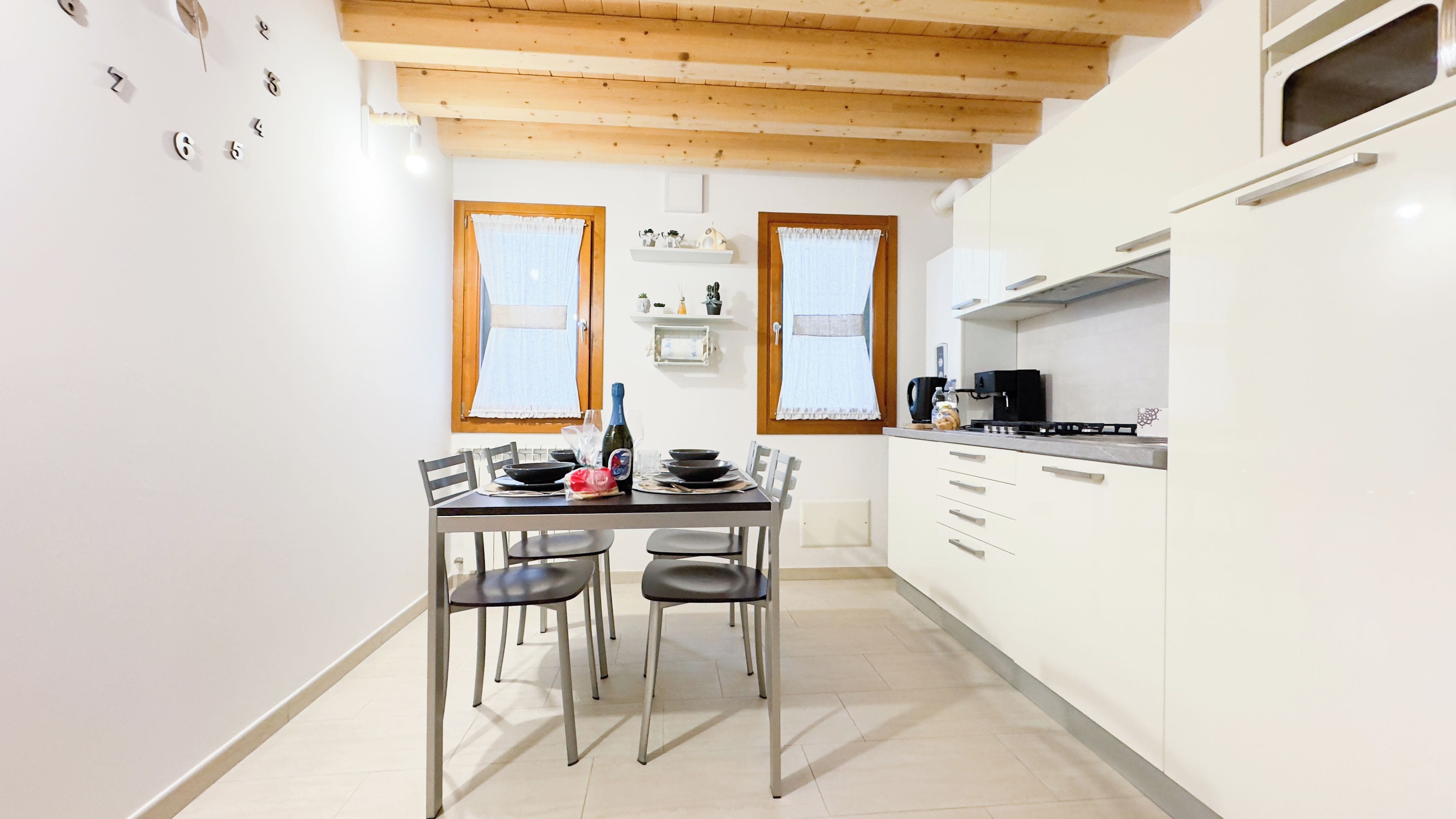 A kitchen with white cabinets, a stove, and a dining table with chairs.