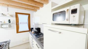 Cozinha equipada com micro-ondas, fogão e armários.