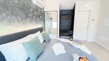 Una habitación de hotel moderna con cama, zona de ducha y armario.