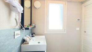A modern bathroom with a white sink, a hairdryer, and a mirror. - Graceful Apartments Purgatory by Ca-sa Check (Chioggia)