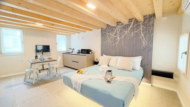 Un dormitorio moderno con cama, escritorio y televisor.