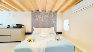Une chambre comprenant un lit, une table de chevet et un coin cuisine.