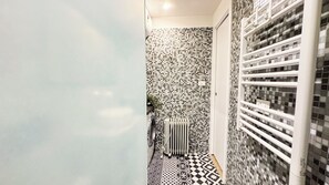A narrow hallway with a tiled floor and walls, a radiator, and a white door. - Gesuiti Cozy and Central Apartment by Ca-sa Check (Venice)