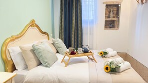 Ein ordentlich bezogenes Bett mit Kissen, ein Tablett mit Teekanne und Tassen sowie ein Strauß Sonnenblumen.