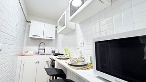 A modern kitchen with white cabinets, a built-in microwave, and a sink. - Gesuiti Cozy and Central Apartment by Ca-sa Check (Venice)