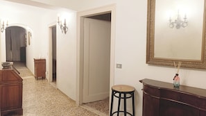 A hallway with a wooden dresser, a mirror with an ornate frame, and a door leading to another room. - Gorgeous Apartment St. Mark Square by Ca-sa Check (Venice)