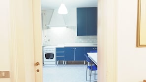 A kitchen with blue cabinets, a white stove, and a blue chair. - Gorgeous Apartment St. Mark Square by Ca-sa Check (Venice)