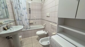 Ein Badezimmer mit Waschbecken, Toilette, Bidet und Badewanne.