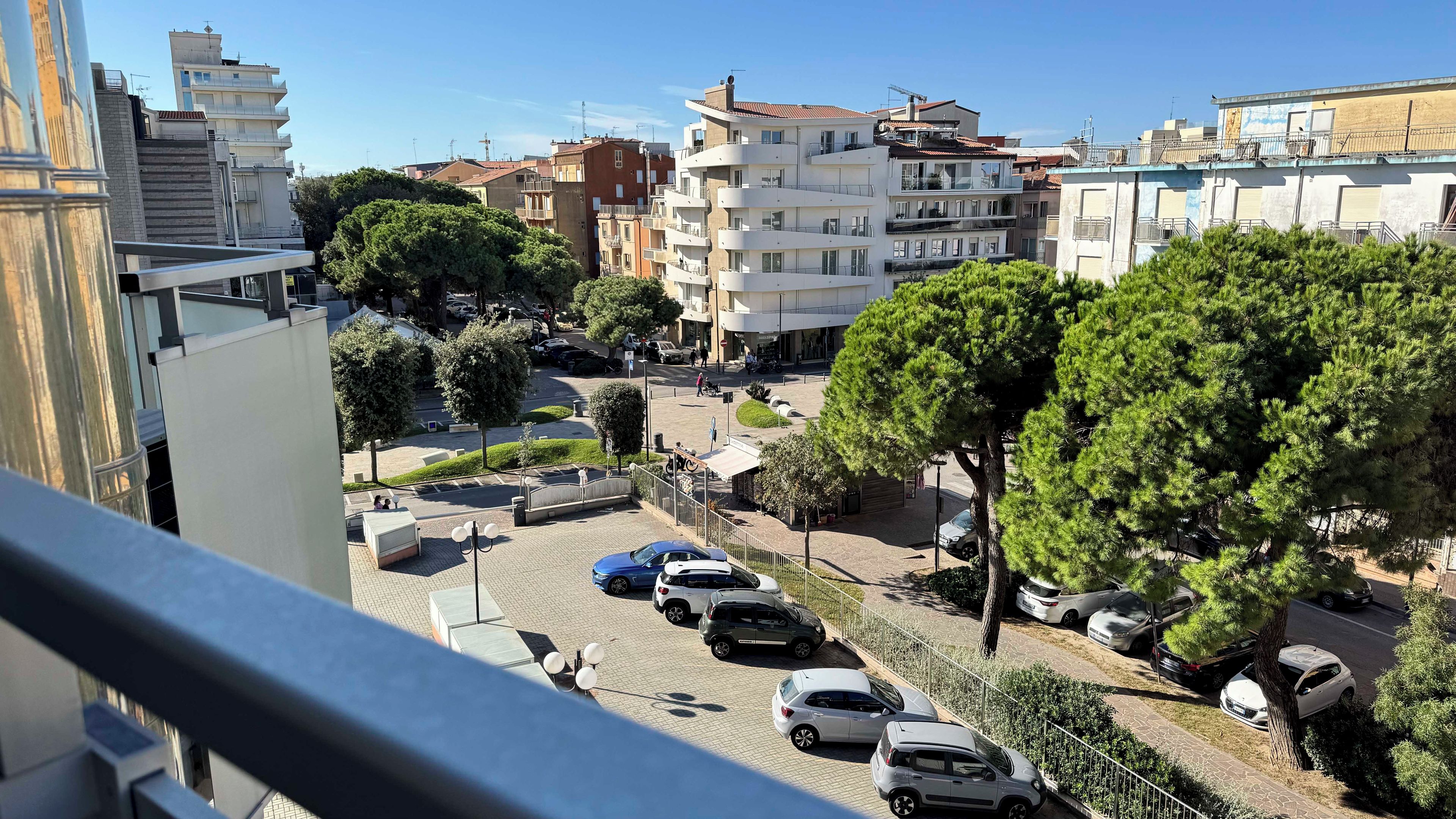 Un quartier résidentiel avec des immeubles à plusieurs étages, des voitures garées et des arbres.