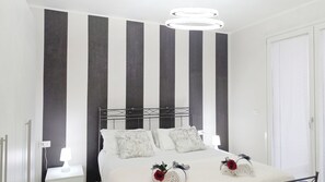A modern bedroom with a bed, two bedside tables, and a large window. - Casa Helios by Ca-sa Check (Chioggia)