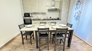 A dining area with a table set for six, equipped with plates, glasses, and cutlery. - Casa Micio by Ca-sa Check (Chioggia)