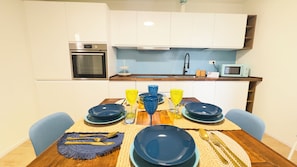A compact kitchen with white cabinets, a built-in oven, a microwave, and a sink. - Ca' Egle by Ca-sa Check (Chioggia)